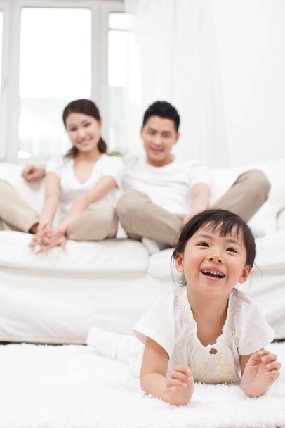 	Young Chinese girl in a living room with parents in the background	 - Фото, зображення