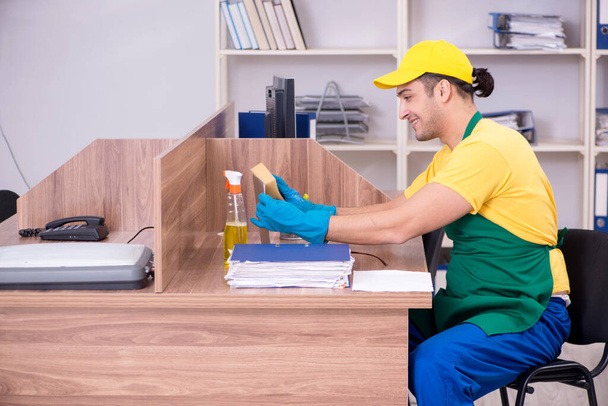 Giovane appaltatore maschile pulizia dell'ufficio - Foto, immagini