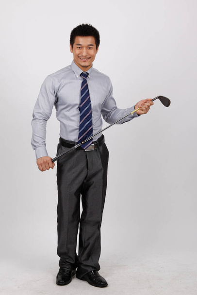 A young business man with a golf wedge - Foto, afbeelding