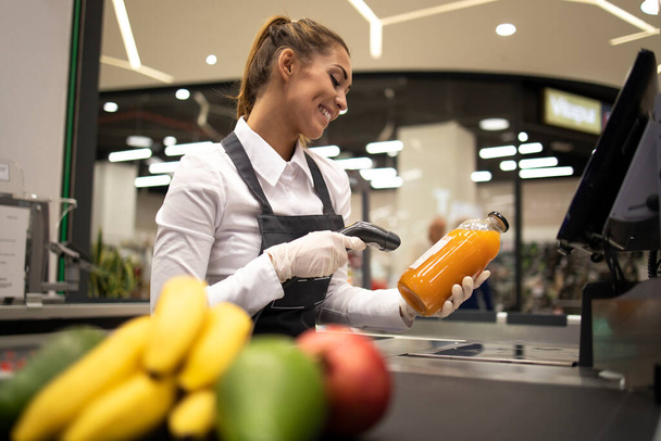 Портрет жінки-каси в супермаркеті сканування штрих-коду продуктів на продаж. Позиція завдання
. - Фото, зображення