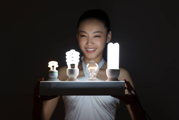 Young woman and a light bulb - Foto, Imagen