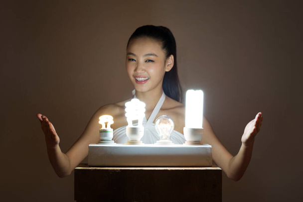 Young woman and a light bulb - Fotó, kép