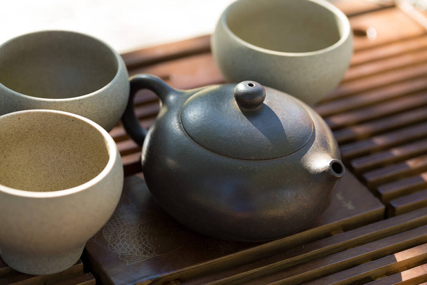 Ceremonia del té chino. Tetera de cerámica hecha de arcilla y tazones sobre un fondo de madera. - Foto, Imagen