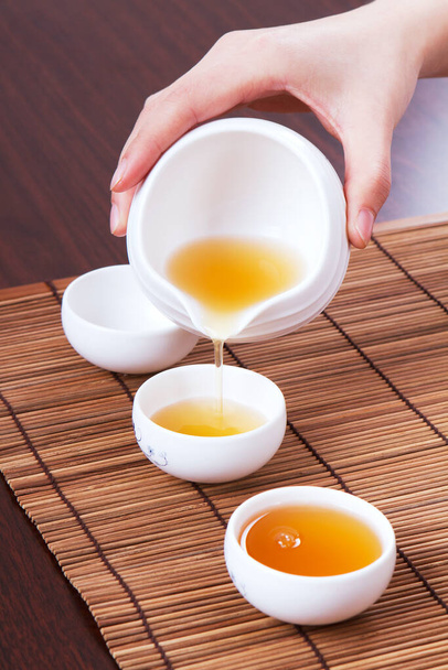 A hand in pouring tea closeup - 写真・画像