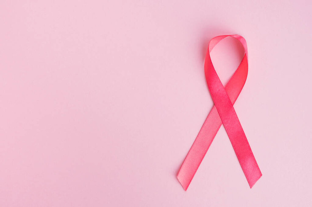 背景にピンクの乳がん啓発リボン。医学と女性の健康の概念.コピースペース,トップビュー - 写真・画像
