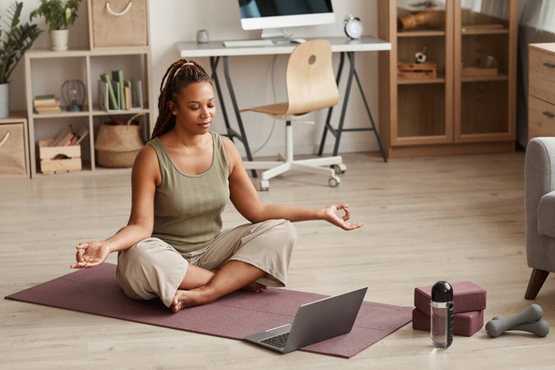 Vrouw doet yoga online thuis - Foto, afbeelding