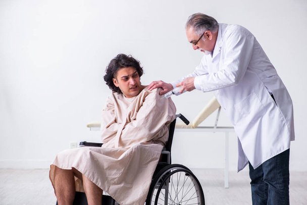 Anciano médico psiquiatra y paciente en silla de ruedas
 - Foto, Imagen