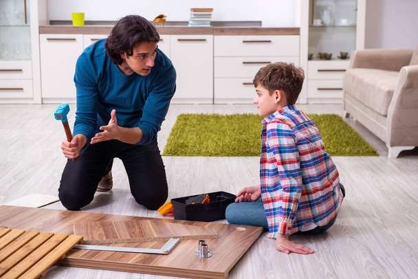 Jovem carpinteiro ensinando seu filho
 - Foto, Imagem