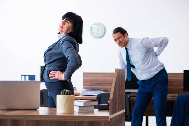 Two employees doing sport exercises in the office - Fotoğraf, Görsel