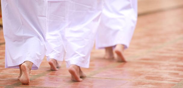 Буддизм у білій тканині практикує медитацію спокійною ходьбою. Жіночий буддизм у білому одязі, який ходить у храмі для роздумів. Чжон Кром - Фото, зображення