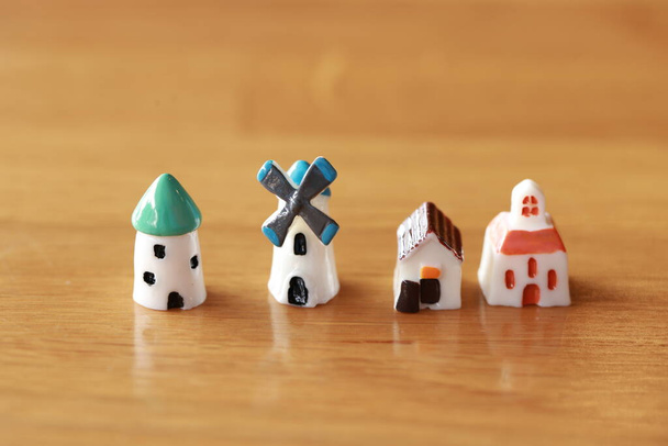 Petite maison, minuscule moulin à vent, petite tour aussi miniature ville natale que des jouets de village sur plancher de bois dans le concept de vie d'idée vivre ensemble pour l'éco-énergie éolienne - Photo, image