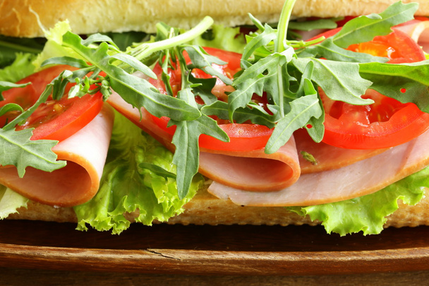 Sanduíche de baguete com rúcula, presunto e tomate
 - Foto, Imagem