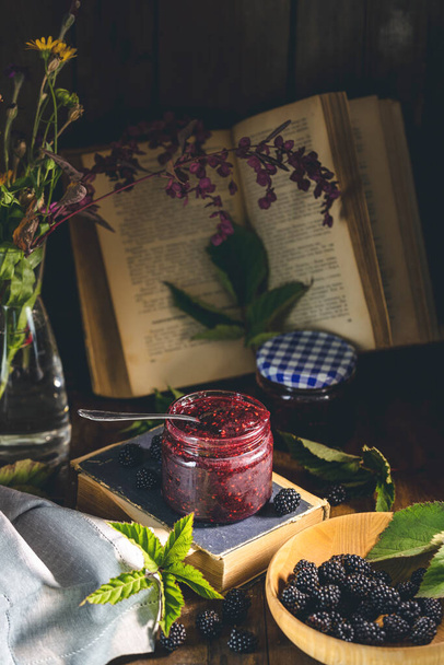 Fresh homemade easy blackberry filling in to the jar. Old dark rustic magic style. Sunny light. - Foto, afbeelding