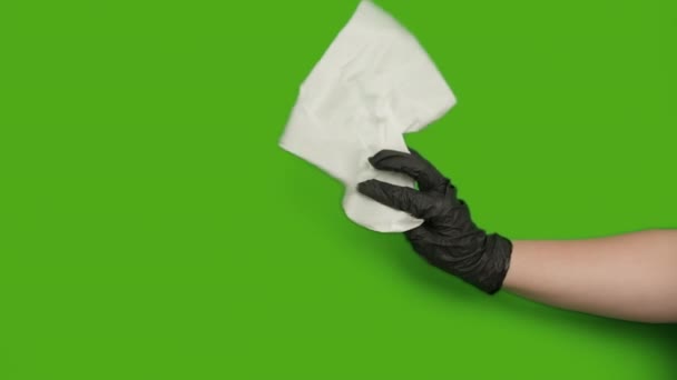 Γυναικείο χέρι σε μαύρο λαστιχένιο γάντι με χαρτοπετσέτα, πράσινη οθόνη, chroma key - Πλάνα, βίντεο