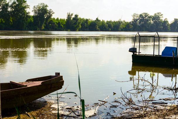 Quai improvisé, lieu de débarquement des bateaux de pêche sur le rivage d'une rivière polluée. - Photo, image