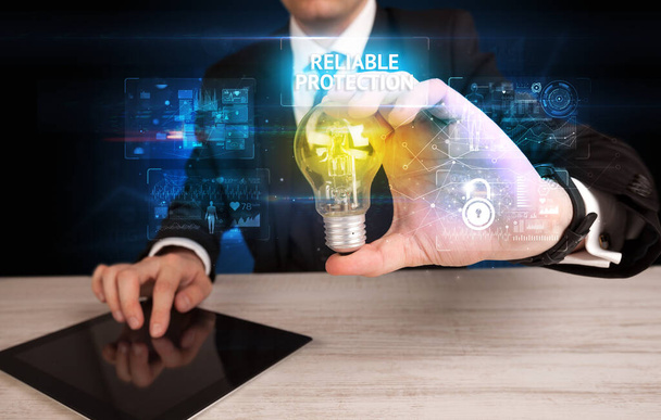 Businessman holding a light bulb, online security concept - Foto, afbeelding