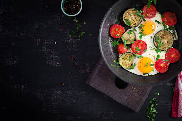 Angielskie śniadanie - smażone jajka, pomidory i bakłażan. Amerykańskie jedzenie. Widok z góry, nad głową, przestrzeń kopiowania - Zdjęcie, obraz