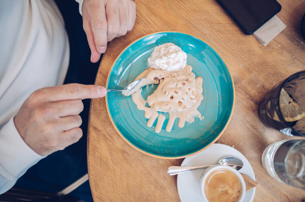 Zbliżenie mężczyzny jedzącego słodkie ciasto i lody w restauracji - Zdjęcie, obraz