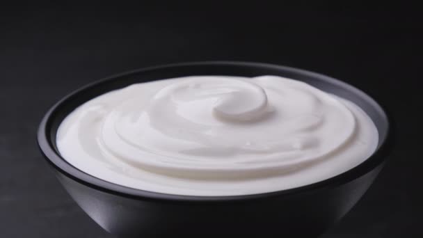Sour cream on black background, greek yogurt - Footage, Video