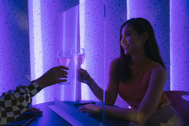 Красивая азиатская тайская женщина делает ура с шампанским в ночном клубе. Вспышка ковид-19. - Фото, изображение