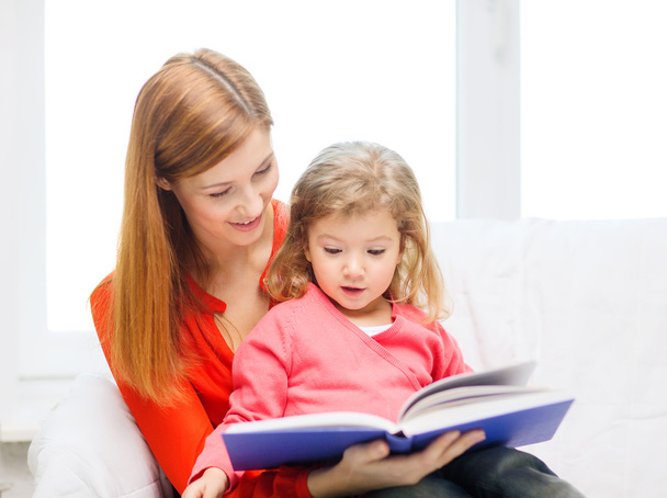 Happy mother and daughter with book - Photo, image