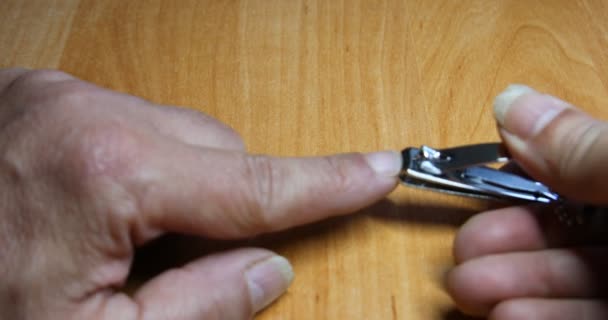 Ο άνθρωπος κόβει τα νύχια του με το πρόχειρο - Πλάνα, βίντεο
