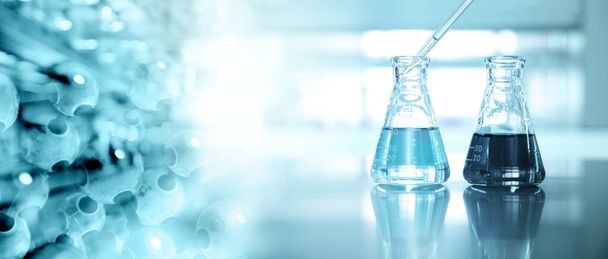 dwie kolby szklane z kroplomierzem i chemią molekularną na tle niebieskiego laboratorium naukowego - Zdjęcie, obraz