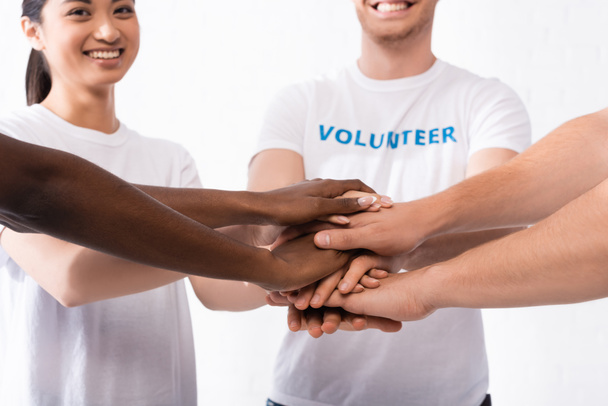 Selective focus of multicultural volunteers holding hands  - 写真・画像
