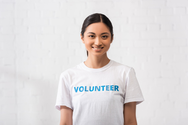 Азиатский волонтер смотрит в камеру в благотворительном центре  - Фото, изображение