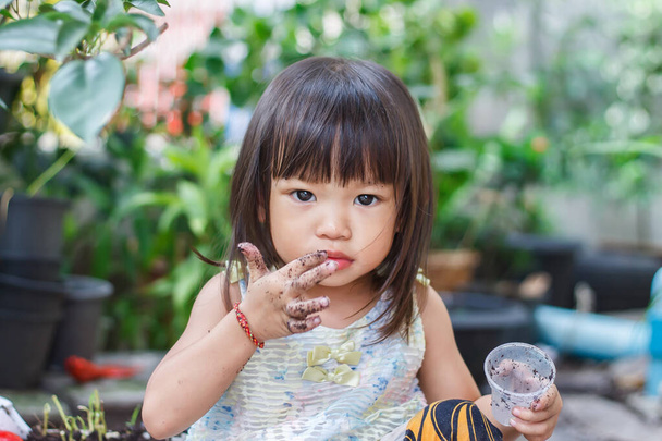 Portraitbild eines 2 Jahre alten Babys. Glückliche asiatische Kindermädchen lächelnd und mit Stoffmaske, Sie spielt mit Schieberegler Spielzeug auf dem Spielplatz, soziale Distanz, Lernen und aktive Kinder Konzept. - Foto, Bild