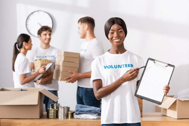 Selektivní zaměření afrického amerického dobrovolníka ukazujícího na schránku v charitativním centru  - Fotografie, Obrázek