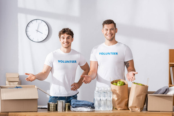 Εθελοντές που δείχνουν με τα χέρια σε δωρεές σε φιλανθρωπικό κέντρο  - Φωτογραφία, εικόνα