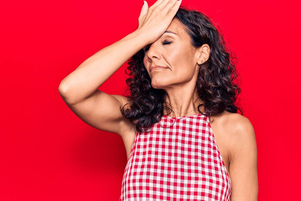 Middle age beautiful woman wearing casual sleeveless t shirt surprised with hand on head for mistake, remember error. forgot, bad memory concept.  - Photo, Image