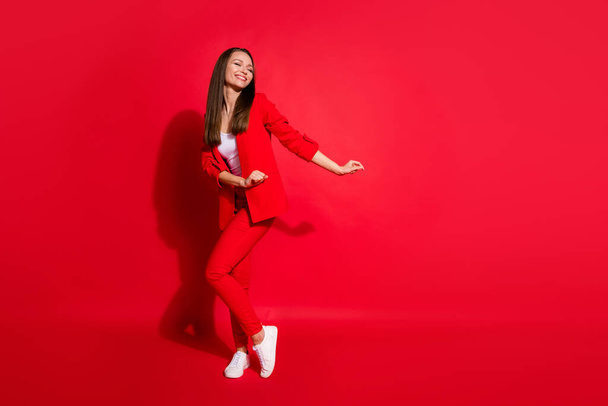 Full length photo of attractive funny business lady successful worker having fun dance corporate party colleagues event wear blazer suit pants shoes isolated red color background - Foto, afbeelding