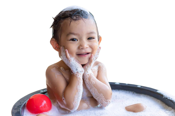 Imagem de retrato do bebê de 2 anos de idade. Bebê feliz menina asiática tomar um banho com bolhas de sabão. Ela sentada em uma banheira e brincando com um brinquedo de bola. Doce sorriso. Em fundo branco isolado
. - Foto, Imagem
