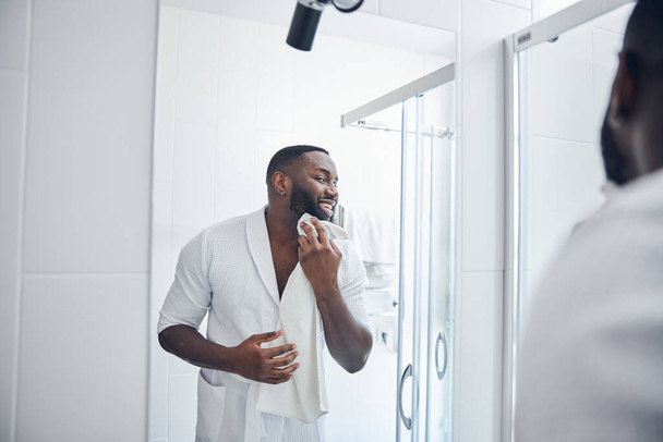 Positive delighted young man doing morning routine - Photo, Image