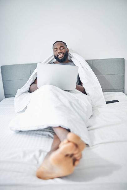 Розслаблений темношкірий чоловік лежить у ліжку
 - Фото, зображення