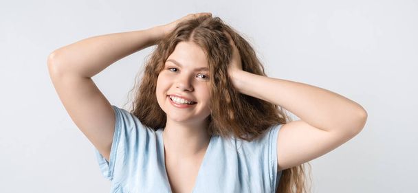 Portrait of attractive carefree european girl, tilting head up and shaking curly hair. Living life to fullest. Having fun and being amused. - Photo, image