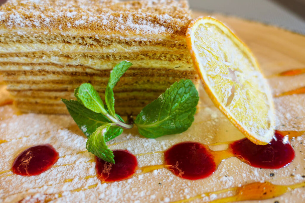Doux morceau de gâteau à la confiture rouge, menthe verte et citron jaune séché gros plan - Photo, image