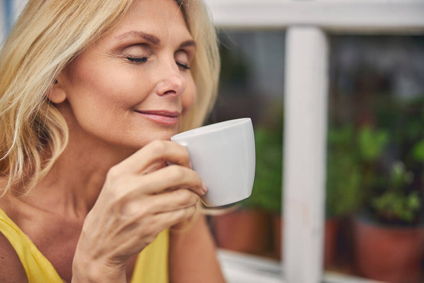Woman holding a cup of hot beverage - Foto, immagini