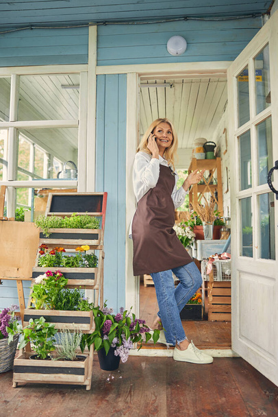 Female in an apron talking on the cellphone - Photo, Image