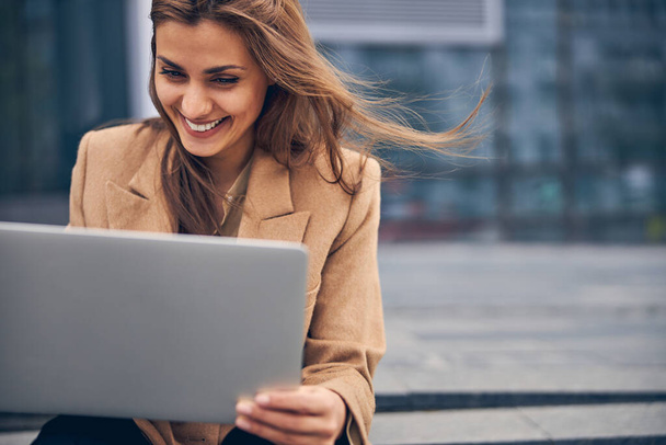 High-spirited young woman using her laptop outside - Foto, Imagem