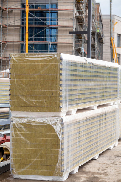 Montón de paneles sándwich de aislamiento térmico en el sitio de construcción. Material de fibra para calentar las paredes del edificio.  - Foto, Imagen