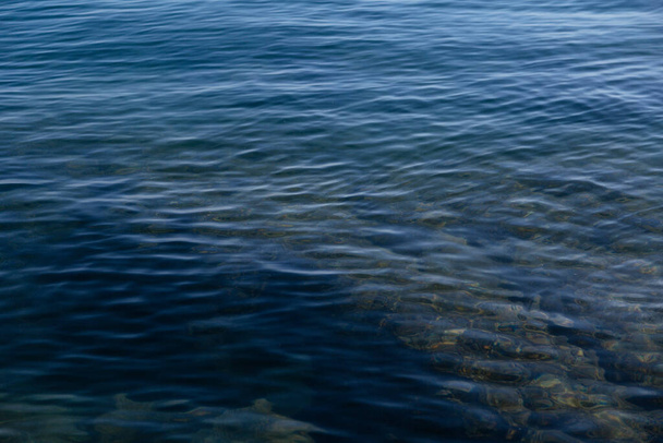 Blauw zeewater achtergrond.Blauw zeeoppervlak met golven.Zee abstracte achtergrond kleurrijke oppervlak van water.Oceaan water textuur behang achtergrond - Foto, afbeelding