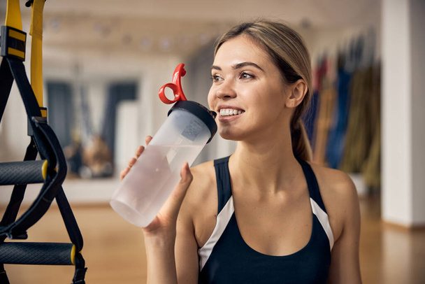 Vidám sportos hölgy ivóvíz edzés közben - Fotó, kép