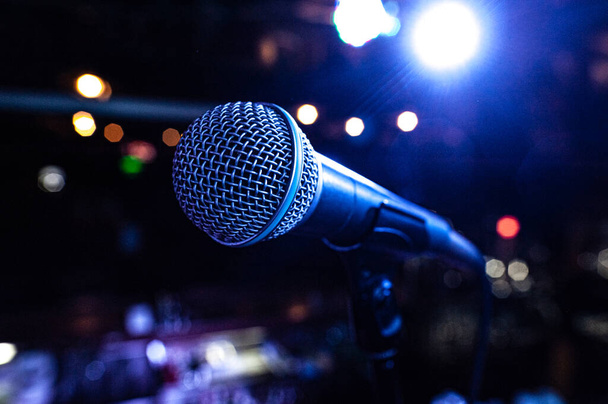 Mikrofonkörper auf der Bühne während eines Konzerts mit bunten Lichtern im Hintergrund - Foto, Bild