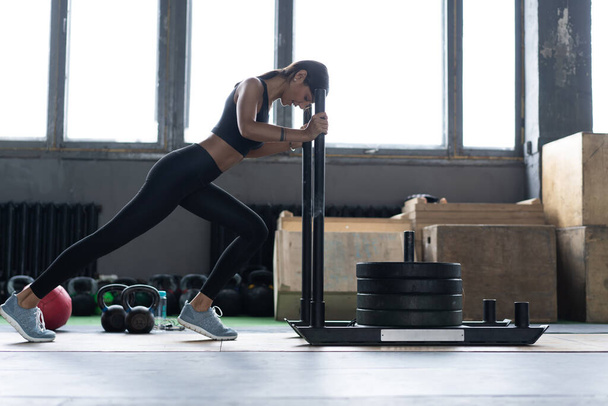 Fit female athlete working out in the gym. Crossfit woman exercising - Fotoğraf, Görsel