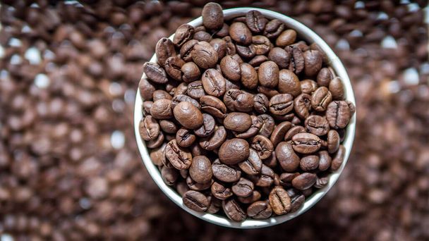 Coffee beans close-up,aromatic roasted coffee beans in a plastic glass,top view - 写真・画像