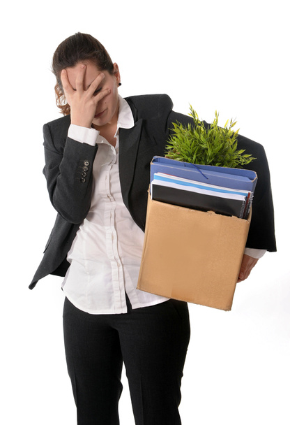 Mujer de negocios enojada llevando caja de cartón disparada desde el trabajo
 - Foto, imagen
