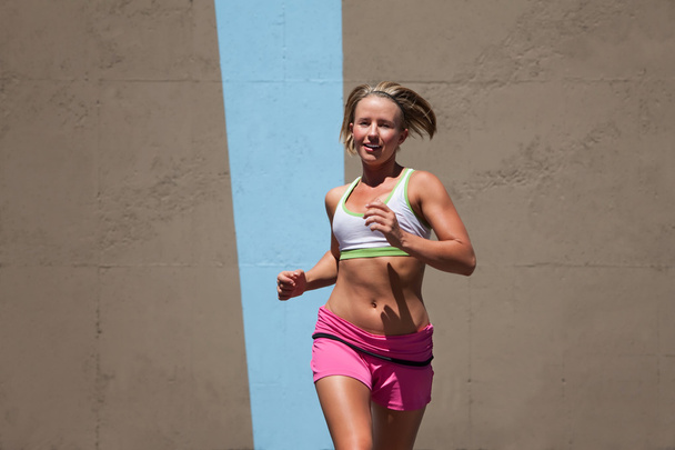 Pretty, focused woman runs to keep in shape. - Zdjęcie, obraz